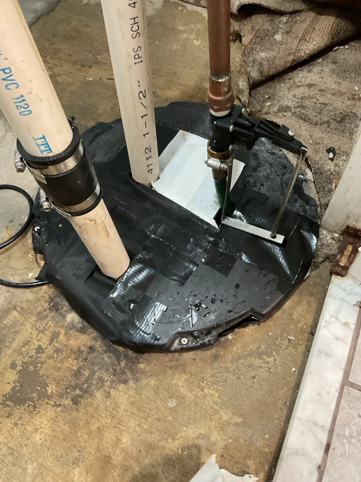 Sump basin with a sealed lid and PVC discharge pipe